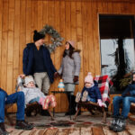 Une famille assise sur un banc devant un chalet, profitant d'un moment de détente en pleine nature.