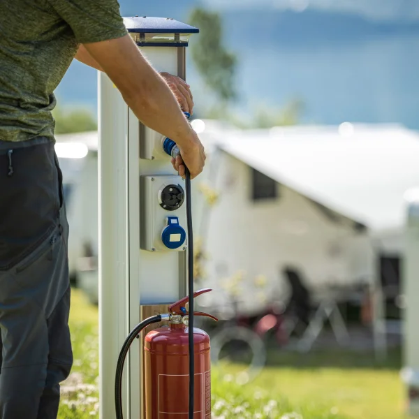 Un homme utilise une pompe solaire pour remplir son camping-car au terrain de camping.