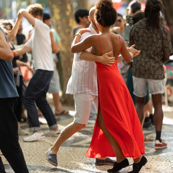 Une femme en robe rouge, souriante, lors d'un voyage en famille.